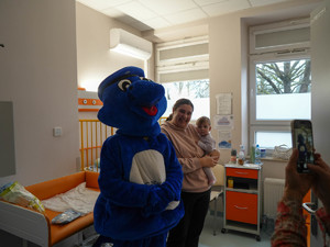 maskotka małopolskiej policji pozuje do zdjęcia z dzieckiem