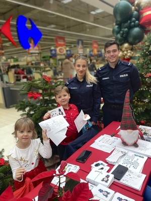 policjanci z dziećmi przy stanowisku edukacyjnym