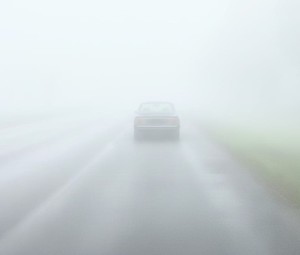 Pojazd jadący po drodze podczas mgły, który ma nie włączonych światła.