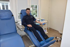 Umundurowany policjant podczas oddawania krwi