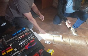 Technik kryminalistyki prezentuje aktorowi zabezpieczanie śladów obuwia