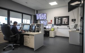 Pomieszczenie dyżurnego. Przy komputerze pracuje policjant