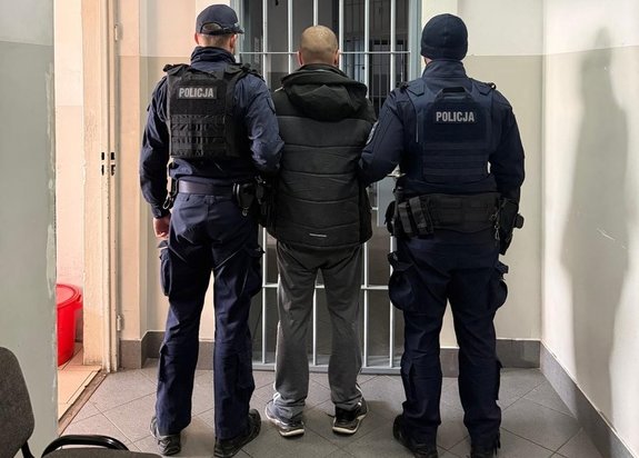 policjanci trzymają zatrzymanego