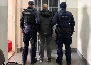 policjanci trzymają zatrzymanego