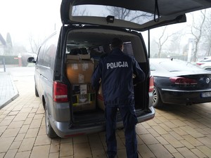 Policjant wyciaga paczki z samochodu