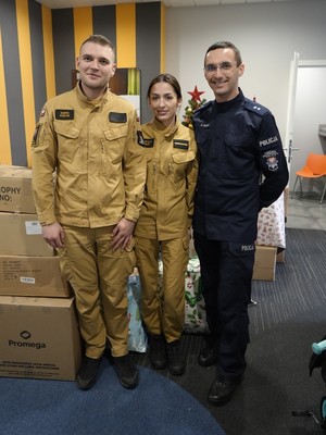 dwoje strażaków oraz policjant przy choince