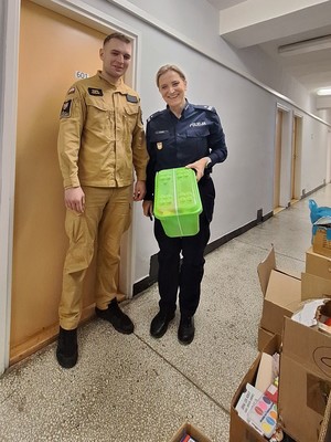 strażak oraz policjantka stoją w korytarzu