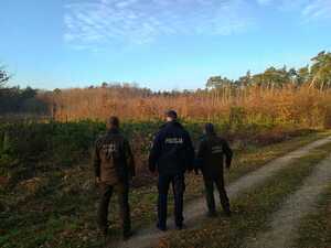 Policjant wraz ze Srażnikami Leśnymi kontrolują tereny leśne