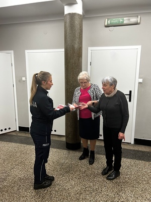 policjantka wręczająca ulotki seniorom