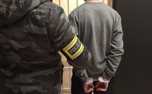 policjant pionu kryminalnego z zatrzymanym