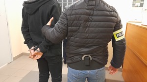 Policjant pionu kryminalnego obok zatrzymany mężczyzna