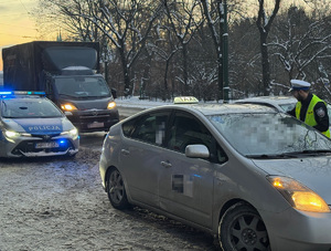 radiowóz i taksówka w tle przejeżdżające samochody