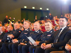Policjanci i marszałek wojweództwa małopolskiego siedzący na sali kinowej