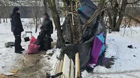 policjant przekazuje odzież osobie w kryzysie bezdomności