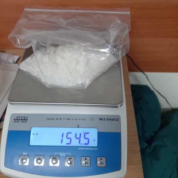 Waga na której znajduje sie woreczek w zawartością białego kryształu