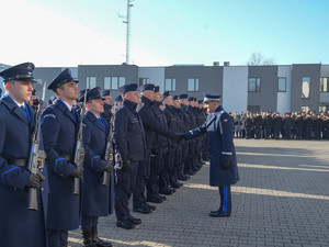 komendant wojewódzki policji symbolicznie wita jednego z nowo przyjętych funkcjonariuszy w szeregach policji