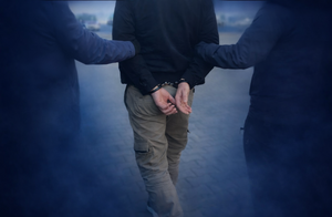 policjanci prowadzą zatrzymanego