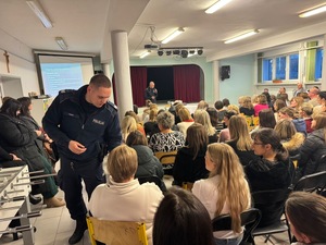 Dzielnicowy wręcza matce zawartośc walizki