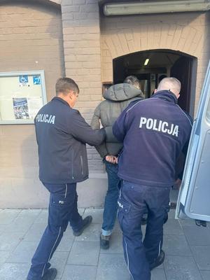 zatrzymany wprowadzany przez policjantów do Aresztu Sledczego w Krakowie