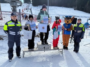 dzieci stojące na podium wraz z dyplomami i nagrodami