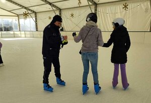policjant rozdajacy odblaski na lodowisku