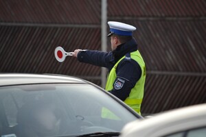 Policjant ruchu drogowego zatrzymujący pojazd do kontroli drogowej