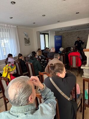 policjant prowadzący spotkanie dla uczestników fundacji zajmującej sie migrntami