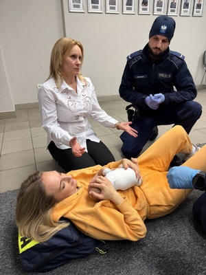 kobieta w bilaej bluzce obok policjnat