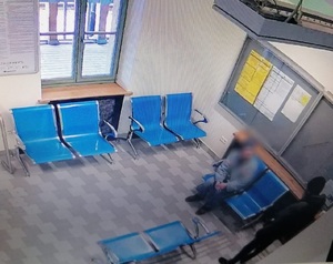 dwóch meżczyzn na poczeklani dworca jeden siedzi drugi stoi