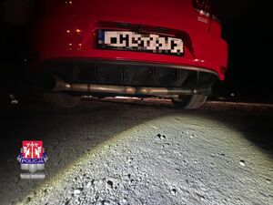 przerobiony wydech samochodu osobowego oświetlony światłem latarki