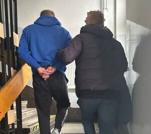 zatrzymany w kajdankach prowadzony przez policjanta