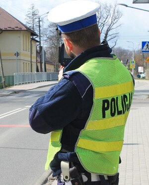 policjant trzymający w ręku radarowy miernik prędkości