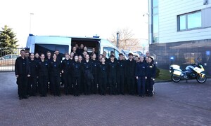 wspólne zdjęcie uczniów przy radiowozie, obok motocykl