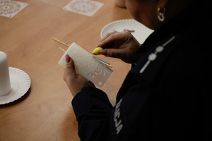 Policjantka maluje świecę na warsztatach