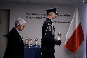 Policjant asysty honorowej składa znicz w imieniu rodziny