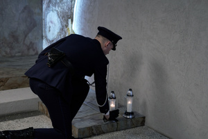 Złożenie znicza przez policjanta w Dniu Pamięci Poległych Policjantów