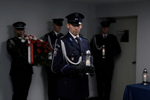 Policjant asysty honorowej składający znicz