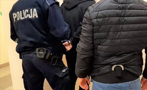 KPP Oświęcim. Policjanci zakładają kajdanki zatrzymanemu.