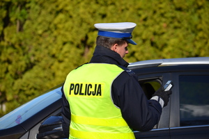 policjant ruchu drogowego dokonuje odczytu wyniku z urządzenia elektronicznego badającego zawartość alkoholu w wdydychanym powietrzu