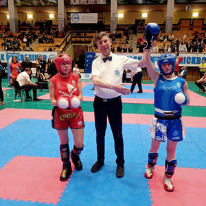 Zawodnicy na tle areny sportowej z sędzia