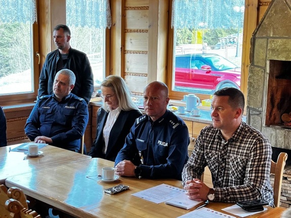 dwóch policjnatów kobieta oraz dwóch mezczyzn w garniturach