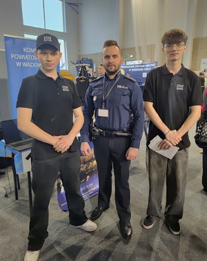 Dwóch chłopaków, a po środku umundurowany policjant