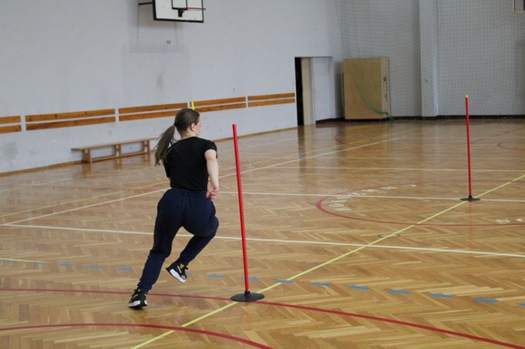 Kobieta wykonująca bieg po kopercie na sali gimnastycznej