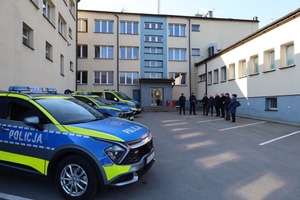 Komenda a przed nią Komendnat Powiatowy Policji w Suchej Beskidzkiej wraz ze swoim Zastępcą prezentuja nowe radiowozy i przedstawiciele samorządów