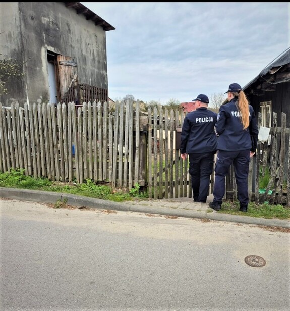 Dzielnicowi podczas wchodzenia na posesję z wizytą.