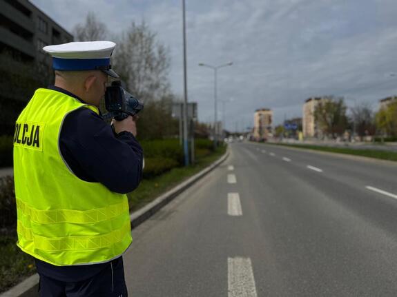 policjant dokonujący pomiaru prędkości na drodze