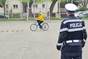policjant ocenia przejazd uczestnika na rowerze po torze przeszkód