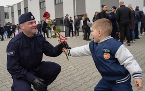 syn wręcza ojcu policjantowi różę