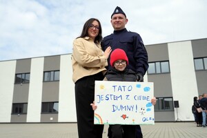 dziecko z transparentem: tato jestem z ciebie dumny wraz z rodzicami