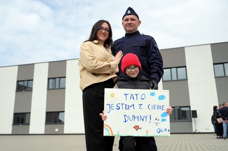 dziecko z transparentem: tato jestem z ciebie dumny wraz z rodzicami